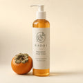 Kaori Persimmon Body Wash bottle beside a ripe persimmon