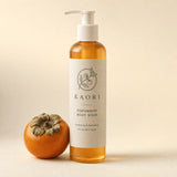 Kaori Persimmon Body Wash bottle beside a ripe persimmon